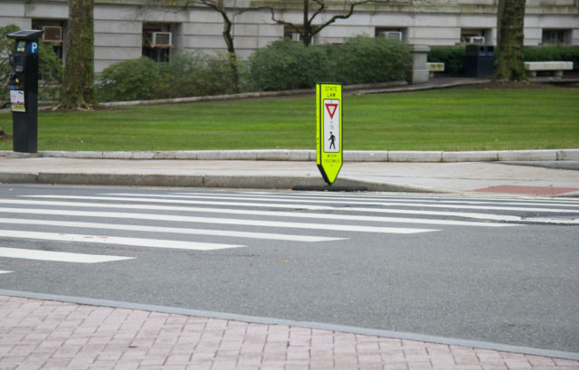 Another yield-to-pedestrian sign placed in gutter instead of on the double yellow lines