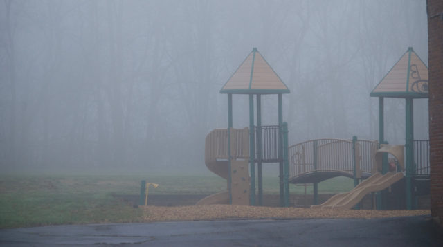 Playground covered in graffiti with fog
