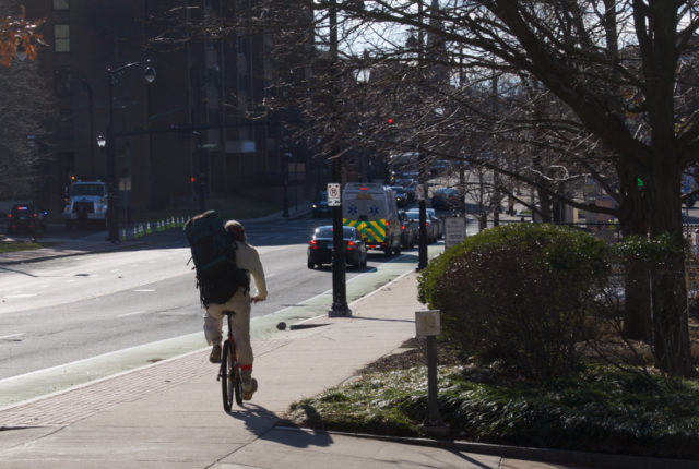 Man riding bicycle on sidewalk