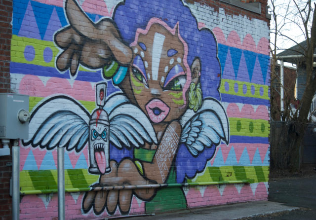 Mural of woman holding spray paint can 