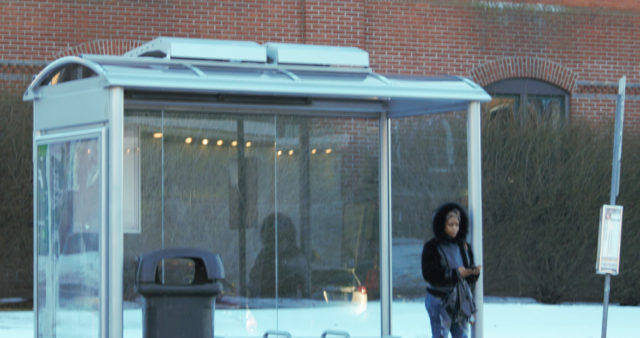 Person waiting inside bus shelter