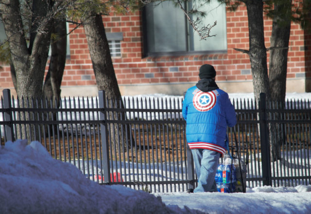 Man walking down road in Captain America jacket