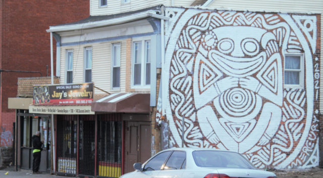 Person opening up store on Park Street near giant mural