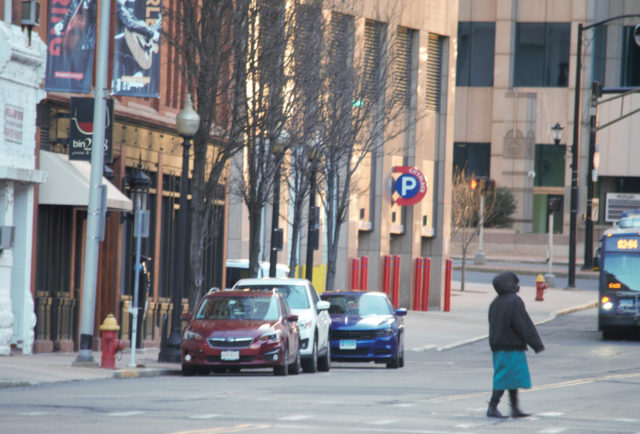 Person wearing teal skirt, crossing street