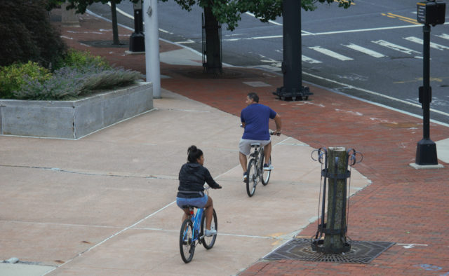 Two people riding bicycles, trying to find ramp