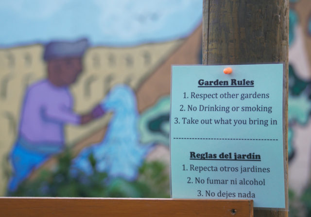 Garden rules sign with mural in background