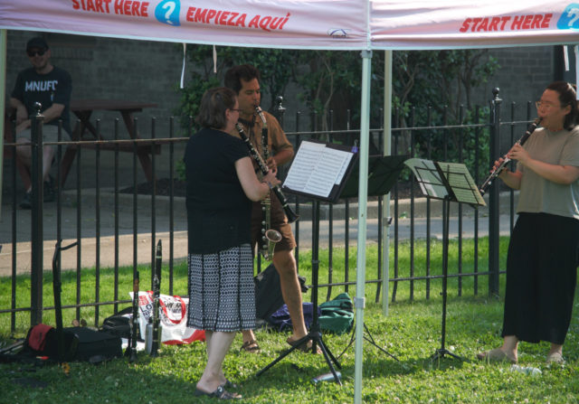 People performing live music under canopy