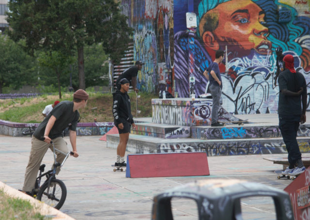 People using skateboards and bmx bikes at skate park